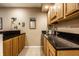 Basement bar area featuring wooden cabinets, black countertops, and stainless steel sink at 12715 Norfolk Ln, Carmel, IN 46032