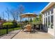 Outdoor deck furnished with an umbrella-covered table and wicker chairs at 12715 Norfolk Ln, Carmel, IN 46032