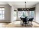 A sunlit dining area features a glass table, blue chairs, and custom window coverings at 12715 Norfolk Ln, Carmel, IN 46032