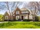 Traditional brick home with well-manicured lawn and mature trees showcasing classic architectural charm at 12715 Norfolk Ln, Carmel, IN 46032