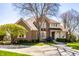 Charming brick home with lush landscaping, mature trees, and inviting entrance, offering classic curb appeal at 12715 Norfolk Ln, Carmel, IN 46032