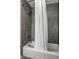 Modern bathroom with a white tub featuring a gray tile surround, sleek showerhead, and a white shower curtain at 12715 Norfolk Ln, Carmel, IN 46032