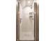 Tiled shower stall featuring white subway tiles, glass door, and corner shelves at 12715 Norfolk Ln, Carmel, IN 46032