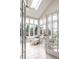 A sun-drenched sunroom with large windows and white wicker seating offers a relaxing retreat at 12715 Norfolk Ln, Carmel, IN 46032
