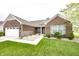 Charming brick home featuring a manicured lawn, two-car garage, and inviting walkway at 14014 Fieldcrest Dr, McCordsville, IN 46055
