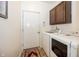 Functional laundry room with washer, dryer, and overhead cabinets near a door with exterior access at 14014 Fieldcrest Dr, McCordsville, IN 46055