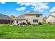 Spacious backyard featuring a brick home, pergola-covered patio, and beautifully manicured lawn at 1611 Connemara Rd, Indianapolis, IN 46217