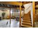 Spacious basement featuring exposed ceiling, stairs, and functional entertainment space at 1611 Connemara Rd, Indianapolis, IN 46217
