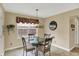 The dining area features a glass table, stylish chairs, a window for natural light, and neutral wall colors at 1611 Connemara Rd, Indianapolis, IN 46217