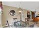 This dining area offers a glass table, comfortable seating, and a view of the kitchen and other living spaces at 1611 Connemara Rd, Indianapolis, IN 46217