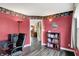 Cozy home office with desk, chair, and bookshelf, set against red walls and wood-look floors at 1611 Connemara Rd, Indianapolis, IN 46217