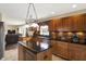 A spacious kitchen features wood cabinets, a center island with dark countertops, and stainless steel appliances at 1611 Connemara Rd, Indianapolis, IN 46217
