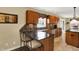 This kitchen boasts wood cabinetry, dark countertops, a stainless steel dishwasher, and stylish barstool seating at 1611 Connemara Rd, Indianapolis, IN 46217