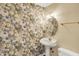Charming powder room featuring floral wallpaper, a pedestal sink, and a decorative mirror with sconces at 1611 Connemara Rd, Indianapolis, IN 46217