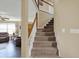 Elegant staircase with carpeted steps and a white railing, leading to the upper level at 1611 Connemara Rd, Indianapolis, IN 46217