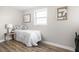 Cozy bedroom featuring modern decor, wood flooring, and natural light from the window at 1613 E Ohio St, Indianapolis, IN 46201
