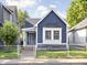 Charming blue home with a well-maintained front yard, a secure fence, and a welcoming front porch at 1613 E Ohio St, Indianapolis, IN 46201