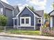 Charming blue home featuring a well-maintained front yard and decorative American flags along the picket fence at 1613 E Ohio St, Indianapolis, IN 46201