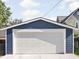 Exterior view of a detached one-car garage with a white door and blue siding at 1613 E Ohio St, Indianapolis, IN 46201