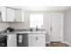 Clean kitchen featuring stainless steel appliances, granite countertops, white cabinets, and wood flooring at 1613 E Ohio St, Indianapolis, IN 46201