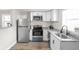 Efficient kitchen featuring stainless steel appliances, granite countertops, white cabinets, and wood flooring at 1613 E Ohio St, Indianapolis, IN 46201