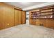 Cozy basement room with wooden paneling, carpet flooring, closet, and built-in shelving perfect for storage or display at 16632 Oak Rd, Westfield, IN 46074