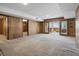 Spacious basement area with paneled walls, sliding glass doors to screened room, and neutral carpeting throughout at 16632 Oak Rd, Westfield, IN 46074