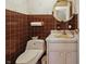 Retro powder room featuring brown tile walls and classic fixtures at 16632 Oak Rd, Westfield, IN 46074