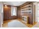 This bedroom features warm wood paneled walls, built in shelving, a window with curtains, and hardwood floors with a rug at 16632 Oak Rd, Westfield, IN 46074
