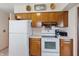 Functional kitchen featuring classic wood cabinets, white appliances, and ample counter space at 16632 Oak Rd, Westfield, IN 46074