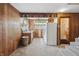 Kitchen area with wood paneling, built-in shelves, refrigerator, carpet, and access to the bathroom and basement at 16632 Oak Rd, Westfield, IN 46074