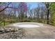 Above ground pool surrounded by stone and concrete deck and a treelined back yard at 16632 Oak Rd, Westfield, IN 46074