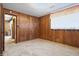 This carpeted room boasts wood paneling, a window with curtains, and a doorway, creating a cozy and inviting space at 16632 Oak Rd, Westfield, IN 46074