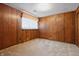 Carpeted room features wood paneling, a window, and a doorway, offering a warm and inviting atmosphere at 16632 Oak Rd, Westfield, IN 46074