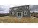 Gray home with large windows, sliding glass doors, and a backyard with newly planted grass at 17062 Cowbell Dr, Noblesville, IN 46060