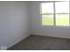 This bedroom has neutral carpet and a view of the backyard at 17062 Cowbell Dr, Noblesville, IN 46060