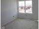 A bright, unfinished bedroom with white walls, trim, and a large window that offers plenty of natural light at 17062 Cowbell Dr, Noblesville, IN 46060