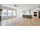 Bright, open-concept living room and kitchen with hardwood floors, modern lighting, and stone fireplace at 19590 Wood Farm Pl, Westfield, IN 46074
