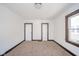 A bedroom with neutral carpet, two doors, and a window with brown trim at 2034 Mansfield St, Indianapolis, IN 46202