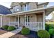 Inviting covered front porch with white railings, perfect for enjoying the outdoors at 2215 Golfside Dr, Lebanon, IN 46052