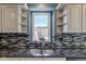 Close up on the kitchen sink with blue mosaic tile backsplash and a window view at 2215 Golfside Dr, Lebanon, IN 46052