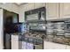 View of kitchen with black appliances, granite countertops, and gray cabinets at 2215 Golfside Dr, Lebanon, IN 46052