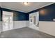 A living room featuring dark blue walls, gray carpet, and views to the dining room at 2215 Golfside Dr, Lebanon, IN 46052