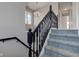 Carpeted staircase with a dark wood railing and a decorative chandelier at 2215 Golfside Dr, Lebanon, IN 46052