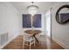 Charming dining room with hardwood floors, modern art, white chairs, and a stylish chandelier at 233 E Saint Joseph St # 2G, Indianapolis, IN 46202
