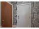 Hallway with a neutral-colored door adjacent to a wood door and stylish wallpaper at 233 E Saint Joseph St # 2G, Indianapolis, IN 46202