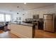 Bright kitchen with stainless steel appliances, granite countertops, white cabinets, hardwood flooring and view to living room at 233 E Saint Joseph St # 2G, Indianapolis, IN 46202