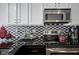 Close-up view of a kitchen with granite counters, stainless steel appliances and tiled backsplash at 233 E Saint Joseph St # 2G, Indianapolis, IN 46202