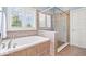 Spa-like bathroom featuring a soaking tub, tile shower, and updated vanity with granite countertop at 2705 April Springs View, Carmel, IN 46074