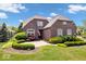 Charming brick home with well-manicured front yard, lush greenery, and beautiful landscaping at 2705 April Springs View, Carmel, IN 46074